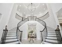 Elegant foyer with curved staircase, detailed iron railings, and a stunning chandelier creates a grand entrance at 2604 S Bryant Cir, Tampa, FL 33629