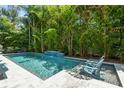 Secluded backyard pool with lush tropical landscaping provides a private oasis for relaxation and recreation at 2604 S Bryant Cir, Tampa, FL 33629