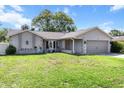 Attractive single-story house featuring a lush green lawn and an attached two-car garage with nice curb appeal at 3074 Dothan Ave, Spring Hill, FL 34609
