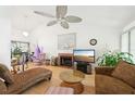 Bright living room with vaulted ceiling, fan, fireplace, and hardwood floors, creating a cozy and inviting atmosphere at 3093 Woodpine Cir, Sarasota, FL 34231
