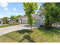 Charming single story home featuring a well-manicured lawn, a two car garage, and tropical landscaping at 3605 W Paxton Ave, Tampa, FL 33611