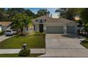 Charming single story home featuring a well-manicured lawn, a two car garage, and tropical landscaping at 3605 W Paxton Ave, Tampa, FL 33611