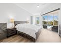 Serene main bedroom featuring wood-look floors, neutral decor, and sliding glass doors to the pool area at 4612 Barracuda Dr, Bradenton, FL 34208