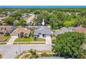 An aerial view showcases this lovely home, nestled among trees and landscaping within a quiet neighborhood at 4951 Musselshell Dr, New Port Richey, FL 34655