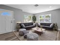 Inviting living room featuring neutral gray walls, wood-look flooring, plush seating, and large windows with natural light at 660 Palm Ave, Tarpon Springs, FL 34689