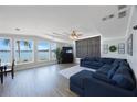 Bright living room with views of the water, wood floors, and a comfortable blue sectional sofa at 9416 Star Gazer Ln, Riverview, FL 33578