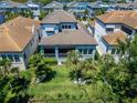 A bird's eye view reveals a manicured lawn, tropical trees, and a covered porch at 1025 Seagrape Dr, Ruskin, FL 33570