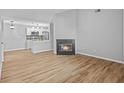 Bright living room featuring wood floors, a fireplace, and an open floor plan to kitchen at 10265 Gandy N Blvd # 1406, St Petersburg, FL 33702