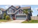 Stylish two-story house featuring a symmetrical facade, a two-car garage, and meticulously maintained landscaping at 11938 Bahia Valley Dr, Riverview, FL 33579