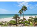 Expansive beach view with palm trees and clear skies, offering a serene and tropical backdrop at 1520 Gulf Blvd # 404, Clearwater, FL 33767