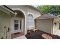 Welcoming front entryway with a charming archway and manicured landscaping at 15209 Arbor Hollow Dr, Odessa, FL 33556