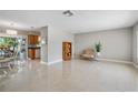 Open-concept living room showcases neutral walls, tile flooring, and a glimpse into the adjacent kitchen and dining area at 1809 Stancel Dr, Clearwater, FL 33764