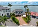 Stunning waterfront home with a paver driveway, two-car garage, and beautifully landscaped yard at 2250 Donato Dr, Belleair Beach, FL 33786