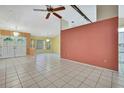 Spacious living area showcasing tile floors, a ceiling fan, and a bright and airy ambiance at 2360 Sutton Pl, Spring Hill, FL 34608