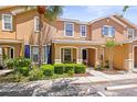 A tan two-story townhome with blue shutters, a well-kept lawn, and a cozy front porch at 2529 Harn Blvd # 2, Clearwater, FL 33764
