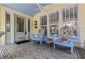 Inviting front porch featuring tile flooring, comfortable chairs, and a blue painted ceiling at 341 14Th Ave Ne, St Petersburg, FL 33701