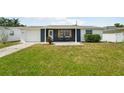 Charming single-story home featuring a well-maintained lawn, attached garage and inviting front patio at 3813 Luma Dr, Holiday, FL 34691