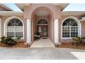 Elegant front entrance featuring double doors, arched windows, and white columns at 4022 Valrico Grove Dr, Valrico, FL 33594