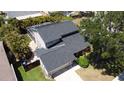 An aerial view of the home showcasing the roof, screened-in porch, landscaping, and surrounding neighborhood at 4915 Pennsbury Dr, Tampa, FL 33624
