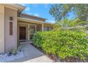 Inviting home entrance featuring a wooden front door and lush greenery that adds a touch of nature at 4915 Pennsbury Dr, Tampa, FL 33624