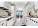 Bright galley style kitchen with white appliances, ample counter space and views of the living room at 5267 81St N St # 8, St Petersburg, FL 33704