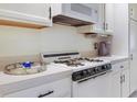 Bright kitchen features white appliances, cabinetry, counters, and dark hardware at 5267 81St N St # 8, St Petersburg, FL 33704