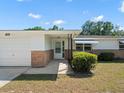 This house features a covered front entry and attached two-car garage at 7346 Hiawatha Pkwy, Spring Hill, FL 34606