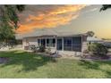 Manicured backyard with lush lawn, screened lanai, and a concrete patio area at 8358 Candlewood Rd, Seminole, FL 33777