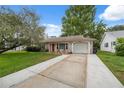 Charming one-story home features a well-maintained front lawn and an attached garage at 8600 Village Mill Row, Hudson, FL 34667