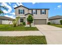 Two-story home featuring a well-manicured lawn and a two-car garage at 11504 Sage Canyon Dr, Riverview, FL 33578