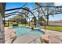 Screened-in pool area features a pristine pool with a rock waterfall design and ample space for relaxation and recreation at 12134 Creek Preserve Dr, Riverview, FL 33579