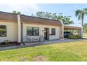 Inviting townhome exterior featuring neutral tones, a quaint seating area, and convenient carport access at 1472 Mission Hills Blvd # 24F, Clearwater, FL 33759