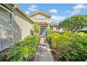 Inviting front entrance with a stone walkway surrounded by lush greenery and beautiful landscaping at 17124 Falconridge Rd, Lithia, FL 33547