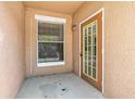 A small entryway featuring a glass-paneled front door and a window with blinds at 18017 Villa Creek Dr # 18017, Tampa, FL 33647