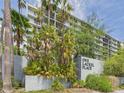 View of the building exterior with lush tropical foliage and a sign reading: One Laurel Place at 201 W Laurel St # 504B, Tampa, FL 33602