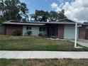 Charming single-story home with a well-manicured lawn, solar panels, and brick accents at 2154 Briarway Dr, Clearwater, FL 33763
