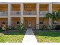 Charming condo building entrance, featuring well-maintained landscaping and covered entryway at 2231 Utopian E Dr # 117, Clearwater, FL 33763
