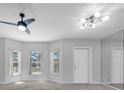 Bright living room with neutral paint, plush carpeting, and natural light from bay windows at 2231 Utopian E Dr # 117, Clearwater, FL 33763