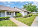 Well-maintained condo exterior with manicured lawn, mature landscaping, and covered entryway at 2506 Laurelwood Dr # 4C, Clearwater, FL 33763