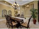 Elegant dining room with coffered ceiling, chandelier, and view to fireplace at 2680 Keystone Springs Rd, Tarpon Springs, FL 34688