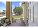 Inviting front porch with a cozy bench, offering a glimpse of the well-manicured lawn and neighborhood at 29432 Coharie Loop, San Antonio, FL 33576