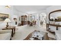 Elegant living room featuring classic furniture, a large mirror, and seamless transitions to dining spaces at 29432 Coharie Loop, San Antonio, FL 33576