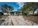 Charming home featuring a light green exterior, wooden pergola and a long driveway at 3962 Poinsettia Dr, St Pete Beach, FL 33706