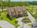 Aerial view of a brick two-story home with a circular driveway, mature landscaping, and golf course views at 4033 Priory Cir, Tampa, FL 33618