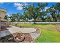 Expansive backyard with lush green grass, mature trees, a circular patio and white fencing at 505 S Larry Cir, Brandon, FL 33511