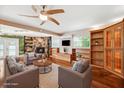 Inviting living room featuring stone fireplace, custom built-ins, modern furnishings, and stylish ceiling fan at 505 S Larry Cir, Brandon, FL 33511