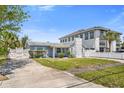 View of the light blue home with white picket fence, unique chimney, and adjacent property at 621 85Th N Ave, St Petersburg, FL 33702