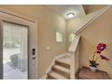 Light-filled entryway with staircase, neutral walls, and modern lighting, creating a welcoming first impression at 6918 Frog Pocket Pl, Tampa, FL 33616