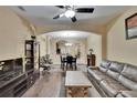 Open-concept living room with hardwood floors, ceiling fan, and stylish furnishings flowing into the dining area at 6918 Frog Pocket Pl, Tampa, FL 33616