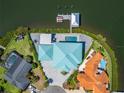 Waterfront property featuring a well-maintained yard, pool, private dock, and lush landscaping at 935 Chipaway Dr, Apollo Beach, FL 33572